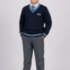 Studio side pose of Indian school boy wearing navy blue DAV full sleeve winter sweater with grey school pants