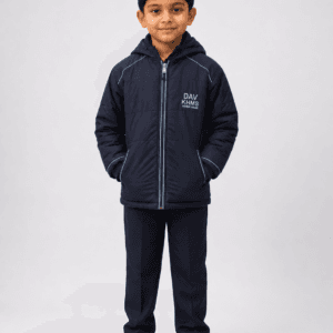 Full body studio photo of Indian boy wearing DAV navy blue padded winter school jacket with formal school trousers and shoes
