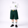 Junior boys DPS-style summer uniform — white half-sleeve monogram shirt with bottle-green shorts, green-striped belt, white socks and black shoes.