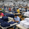 Uniform manufacturer bulk production line — school and corporate uniforms being stitched and packed